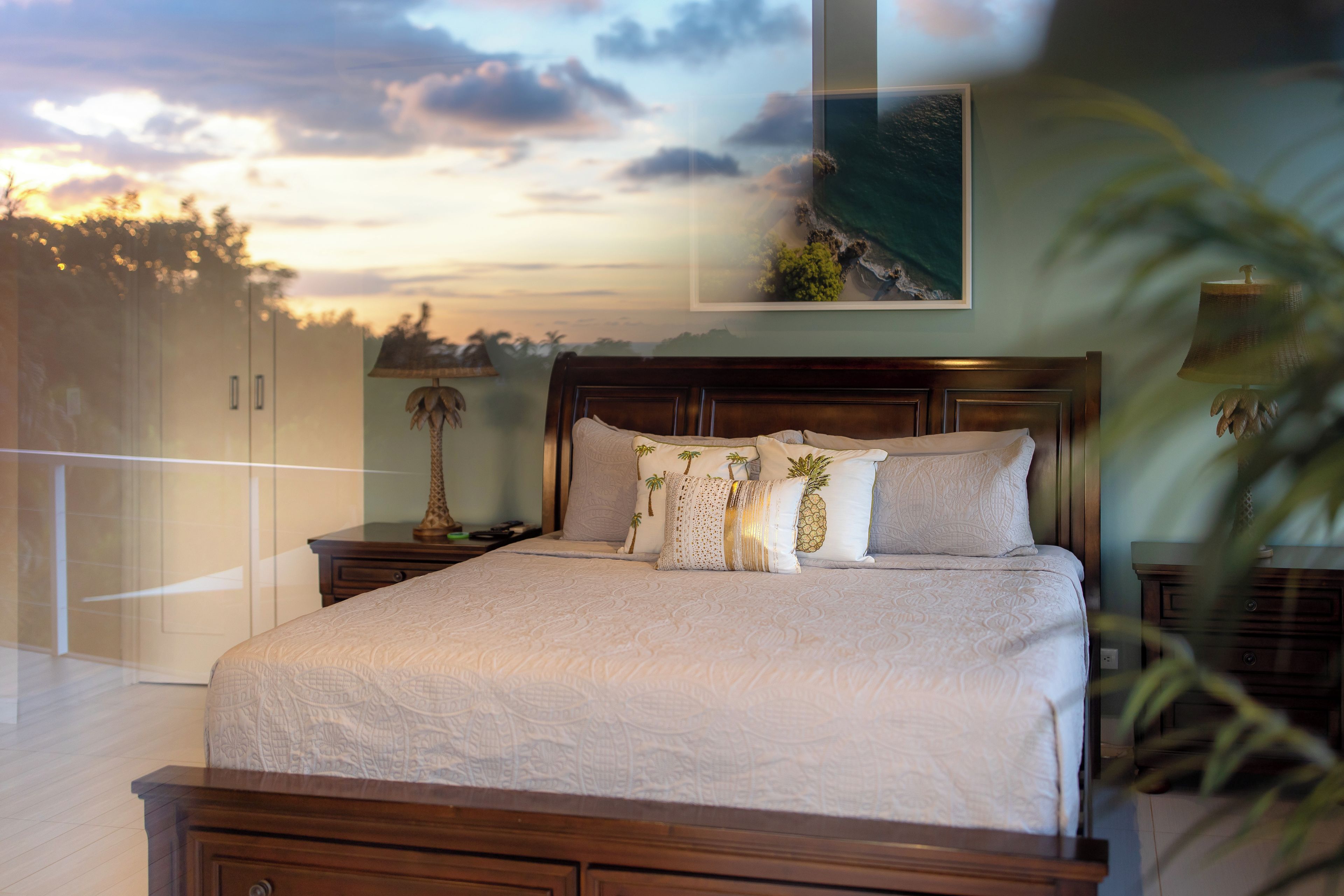 A bedroom with a bed, nightstands, a lamp, and a painting on the wall.