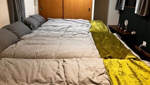 Quarto de hotel com cama, mesa de cabeceira, espelho e guarda-roupa.