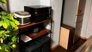 Cozinha compacta com micro-ondas, cafeteira e geladeira.