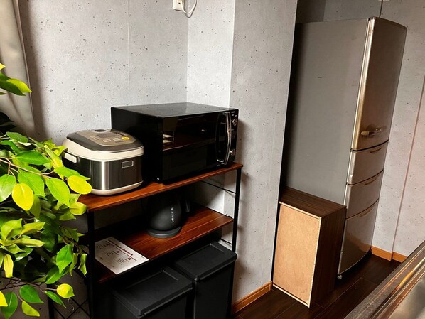 A compact kitchen with a microwave, a coffee maker, and a refrigerator.