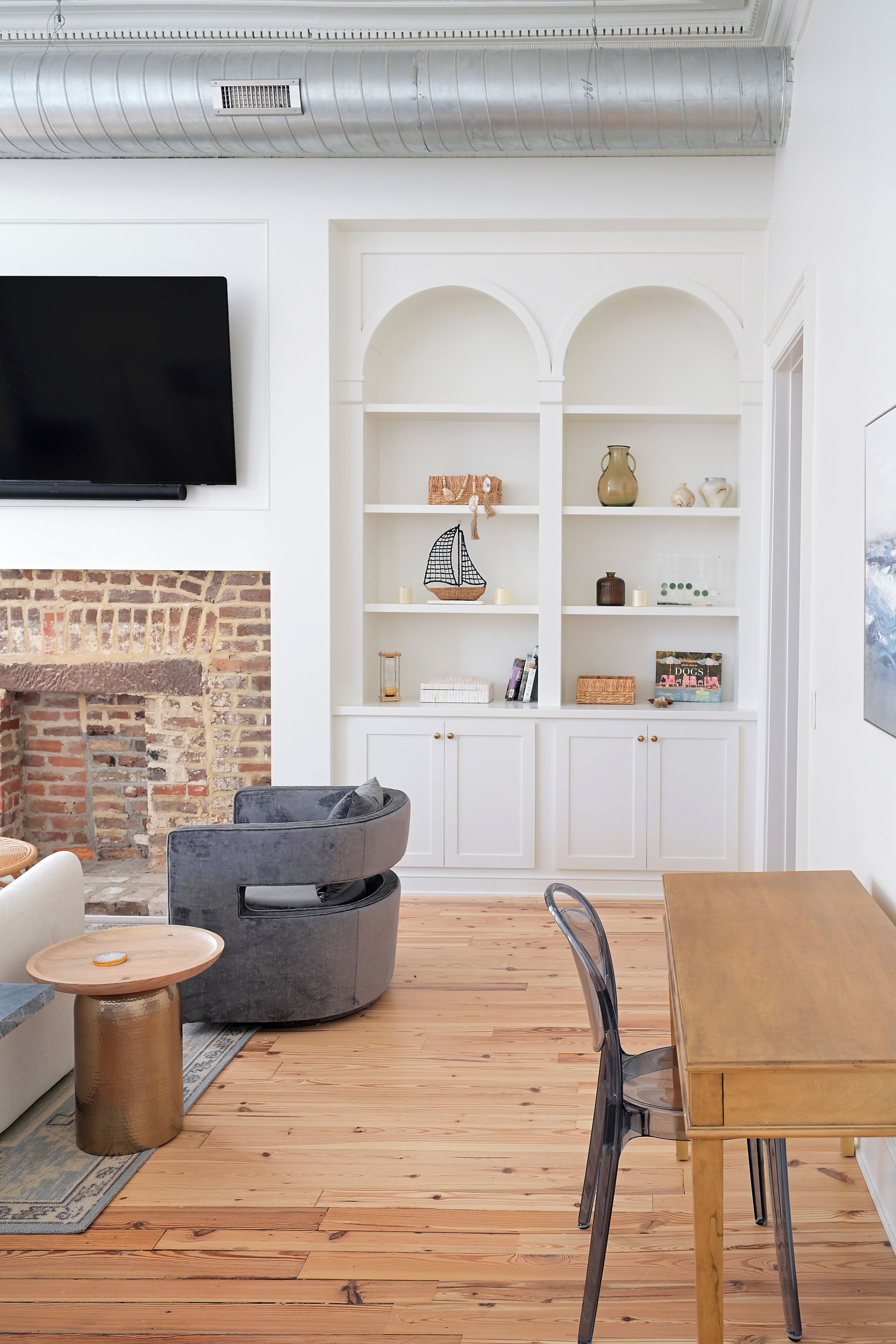 Una sala de estar moderna con chimenea, un televisor de pantalla plana en la pared, una mesa de comedor de madera y una zona de estar confortable.