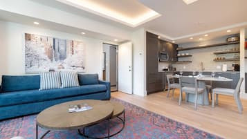 A modern living room with a blue sofa, a coffee table, and a patterned rug.