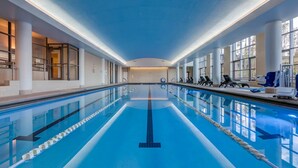 Une longue piscine intérieure avec des couloirs clairement délimités, de grandes fenêtres et un intérieur baigné de lumière naturelle.