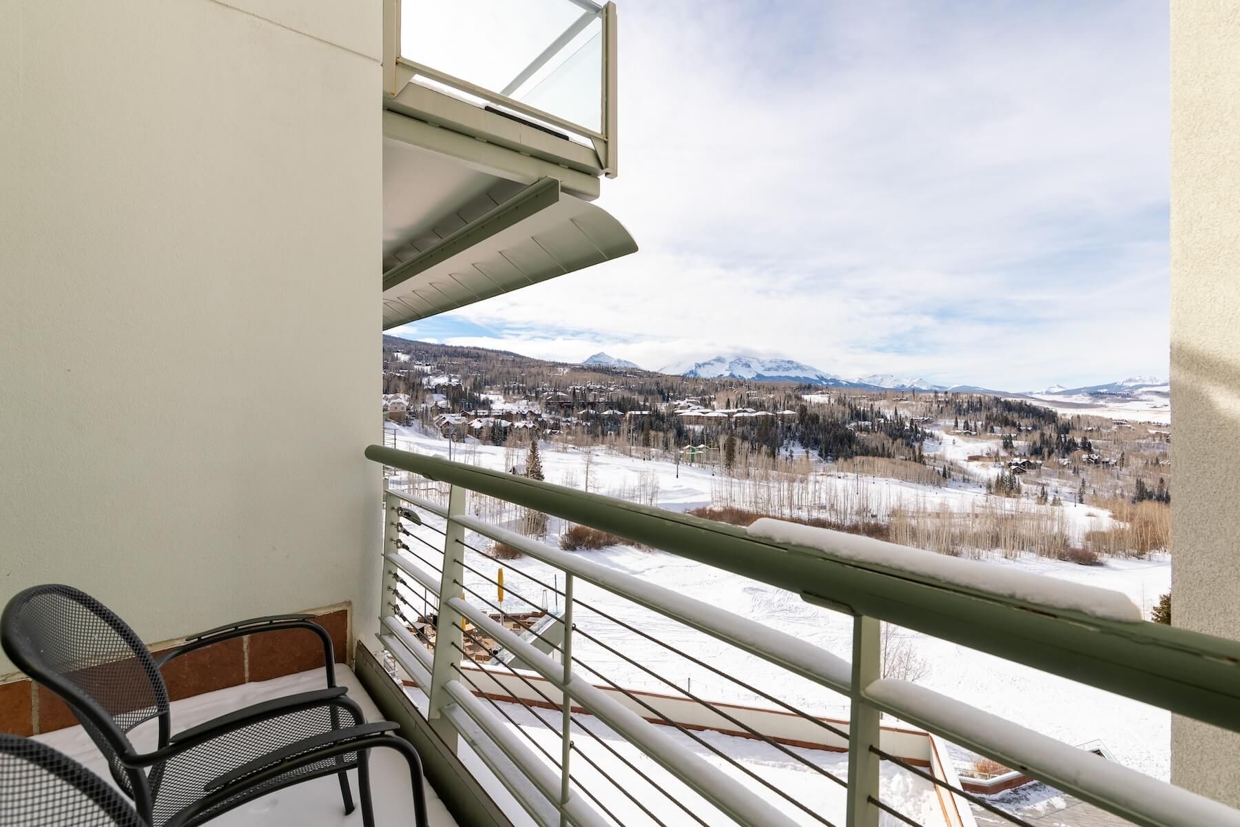 A balcony with a view of a snowy landscape and mountains.