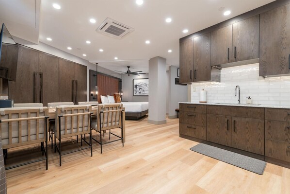 Kitchen area with dining table and king bed on the background