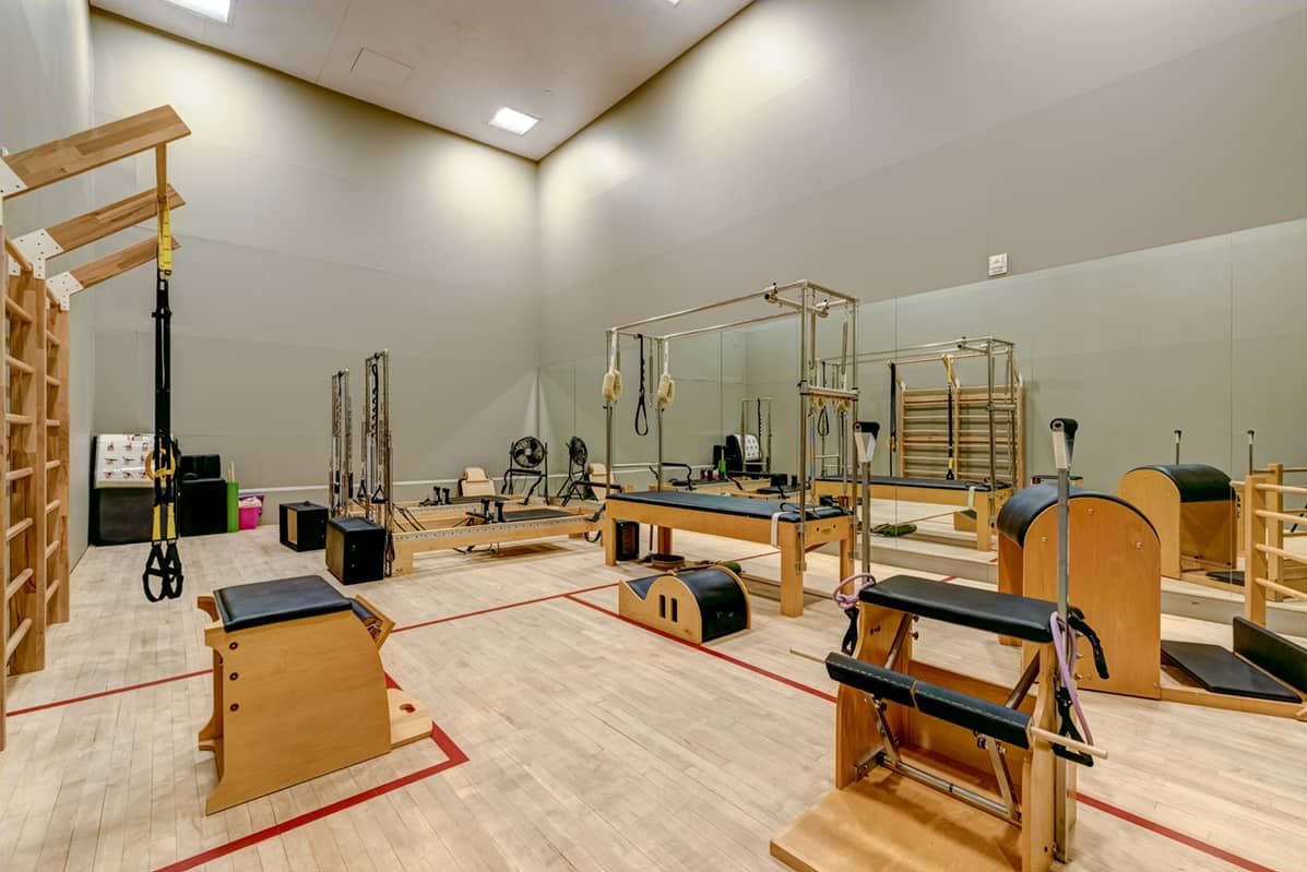 Pilates studio featuring various equipment and wooden fixtures