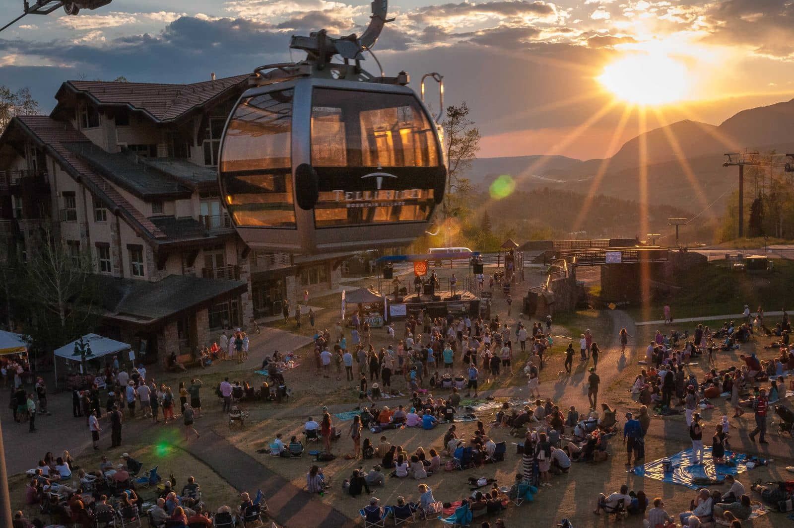 A cable car with a clear view of the surrounding area, including buildings and a crowd of people.