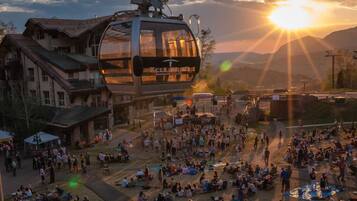 A cable car with a clear view of the surrounding area, including buildings and a crowd of people.