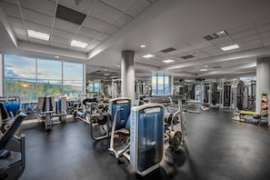 A gym with various exercise equipment, large windows, and a view of the outdoors. - Ski-In/Ski-Out 1BR Suite | Mtn. & Pool Views + Spa (Mountain Village)