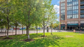 A grassy area with trees and a building with a sign that reads 'AGAVE SOCIAL KITCHEN'. - Spacious 3-bedroom apartment with AC in soothing Cleveland (Cleveland)