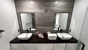Un baño con dos lavamanos, un espejo grande y una encimera oscura.