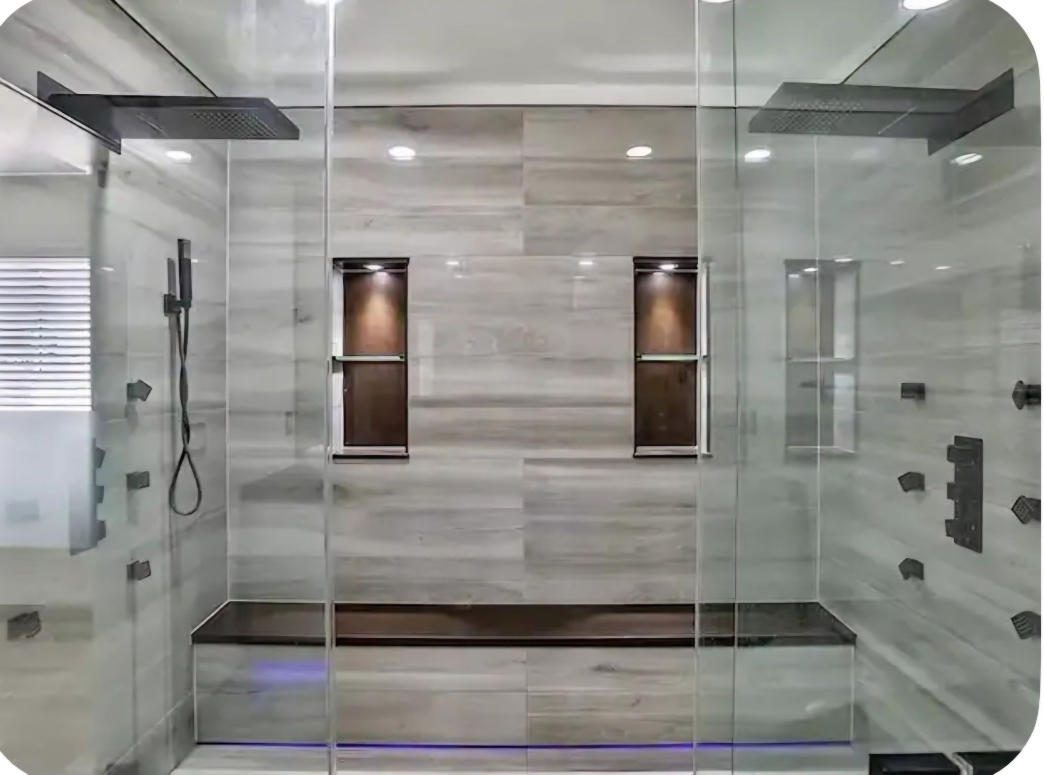 Ein modernes Badezimmer mit Glaswänden, einer Dusche und zwei Waschtischen mit Spiegeln.