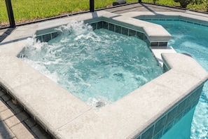 A hot tub with clear water, surrounded by a tiled deck. - Luxury 7BR Disney Home • Pool Spa • Game Room -  Resort Windsor Island (Four Corners)