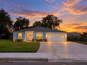 A single-story house with a garage, front porch, and a well-maintained lawn. - New 5BR Home . Walk to Dining . Sleeps 10 (Jacksonville)