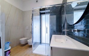 A modern bathroom with a glass shower enclosure, a white sink, and a toilet. - la dolce vita  - terrazza privata e vista mare a Salerno (Salerno)