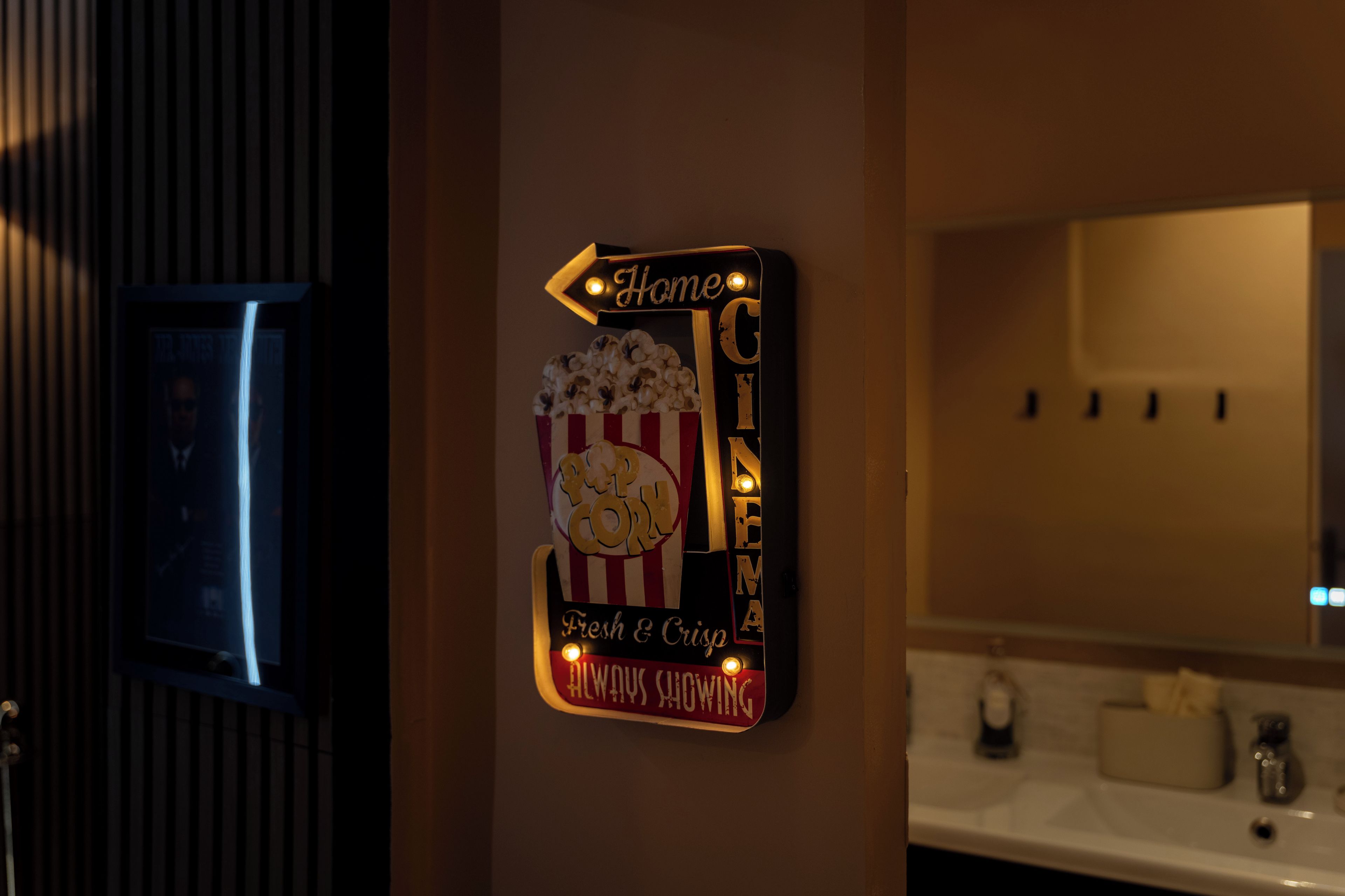 Letrero en la pared con temática de palomitas y cine, que indica un área de cine en casa.