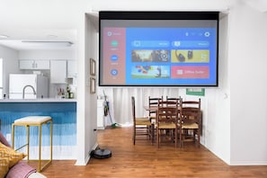 Ein modernes Wohnzimmer mit einem großen Bildschirm, der eine Unterhaltungsinterface anzeigt.