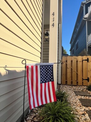 A residential building with a wooden fence and a flag. - The 414: Beach Retreat, Arcade, Fireplace, & Garage (Virginia Beach)