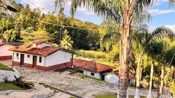 A residential area with houses, a cobblestone street, and lush greenery.