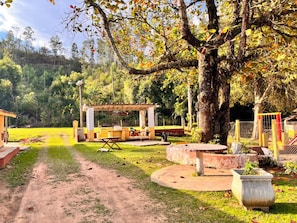 Un parc équipé de tables de pique-nique, d’un espace de repos abrité et d’un sentier de terre.