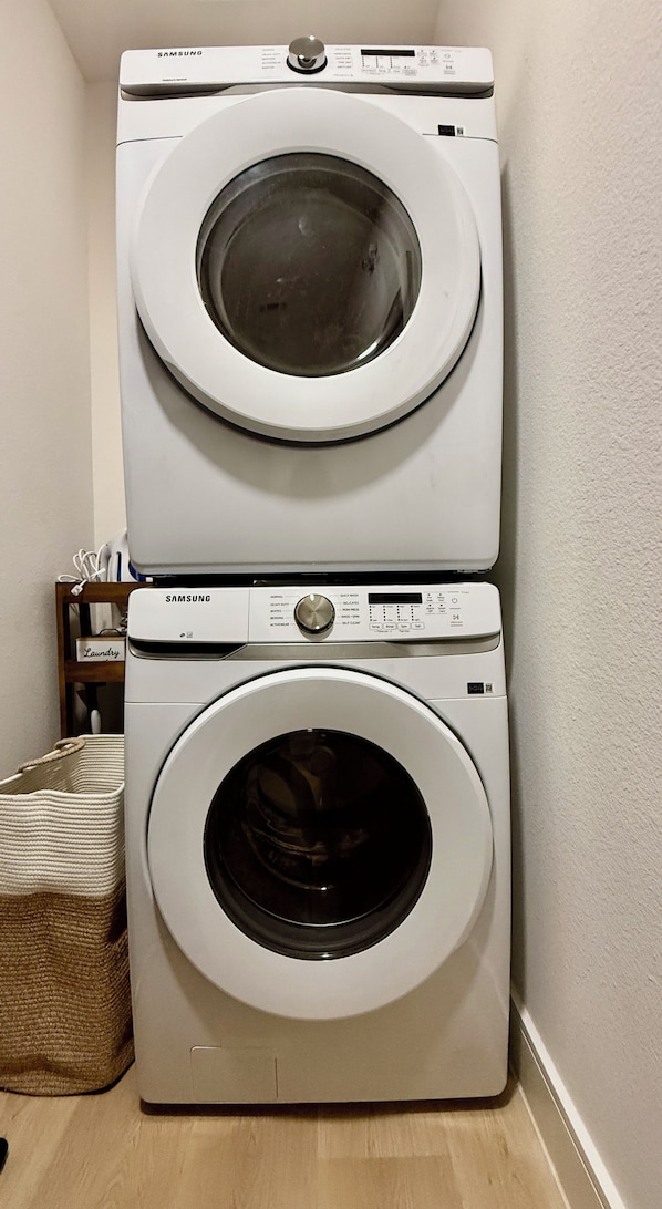 A stacked washer and dryer unit in a laundry room.