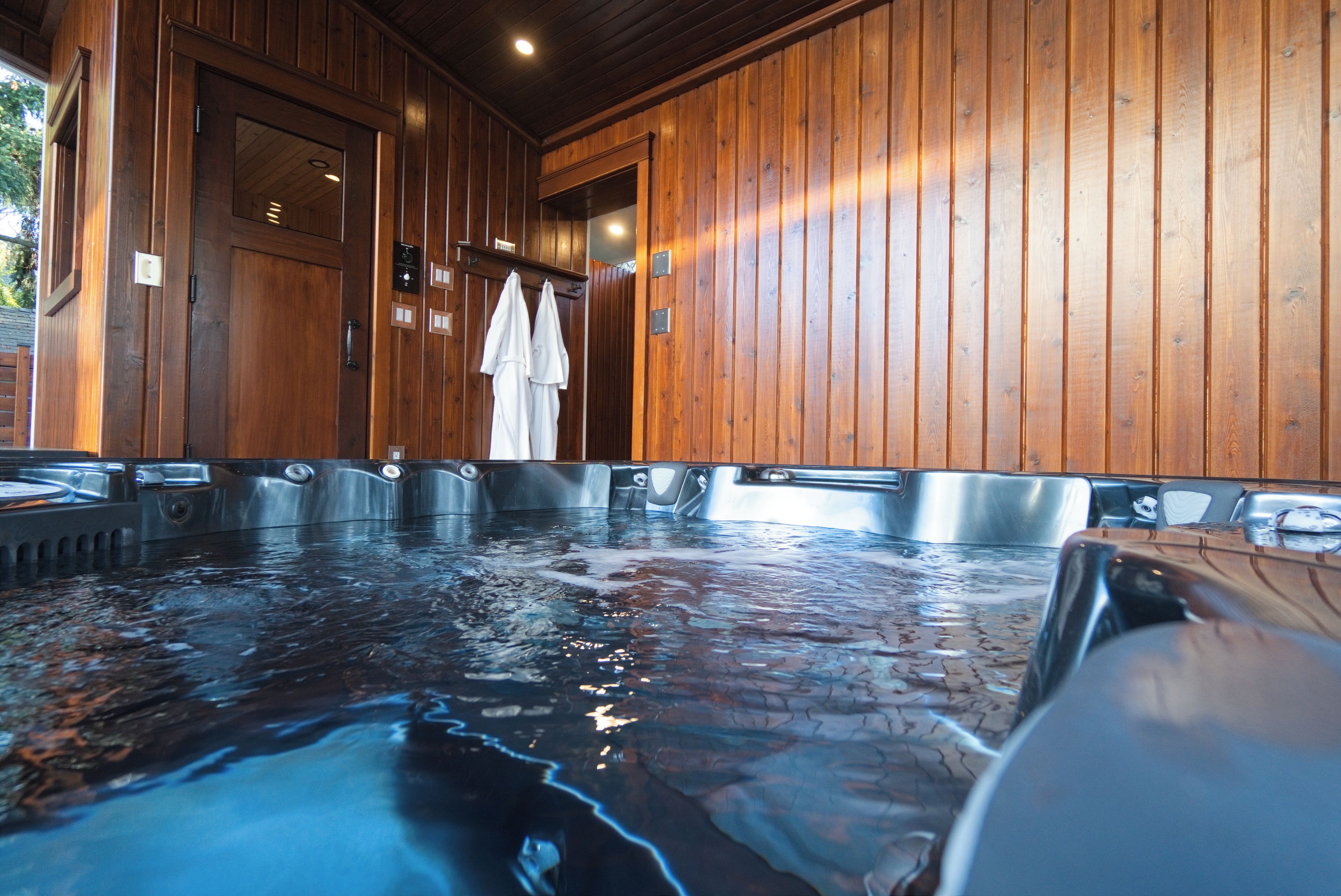 Un espace dédié aux bains à remous, avec des murs en bois et plusieurs bains à remous.