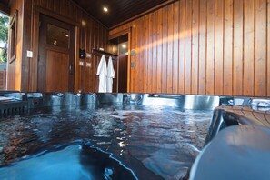 A hot tub area with wooden walls and multiple hot tub tubs.
