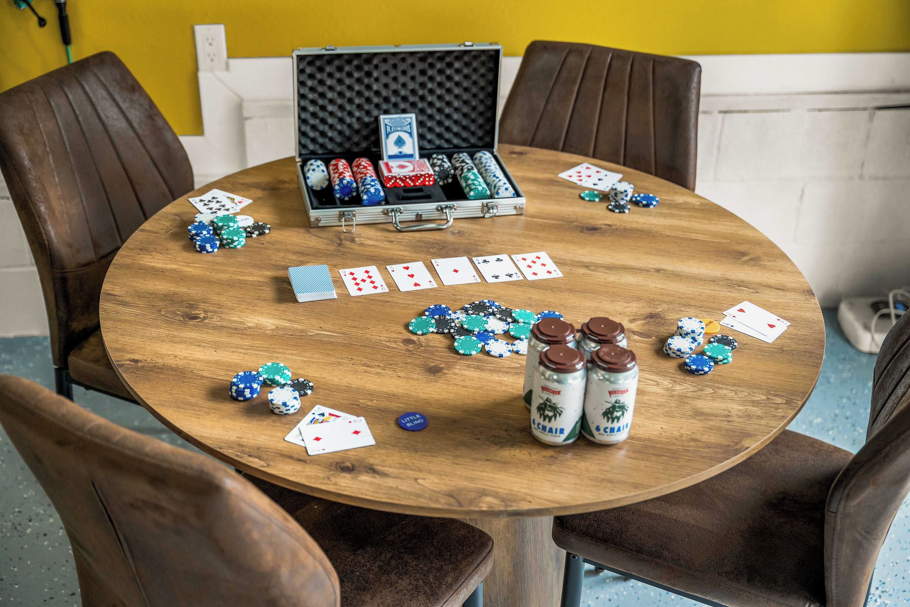 Une table en bois, avec des jetons de poker, un jeu de cartes et deux bouteilles de schnaps.