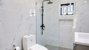 Ein modernes Badezimmer mit Toilette, Dusche und Waschbecken.
