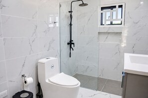 A modern bathroom with a toilet, a shower, and a sink. - Perfect 7-bedroom Village with AC in awesome Higüey location (Higüey)