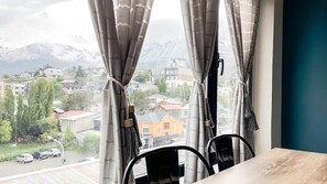 A room with a view of a town and mountains through curtains. - Amanecer del Fuego V (Ushuaia)