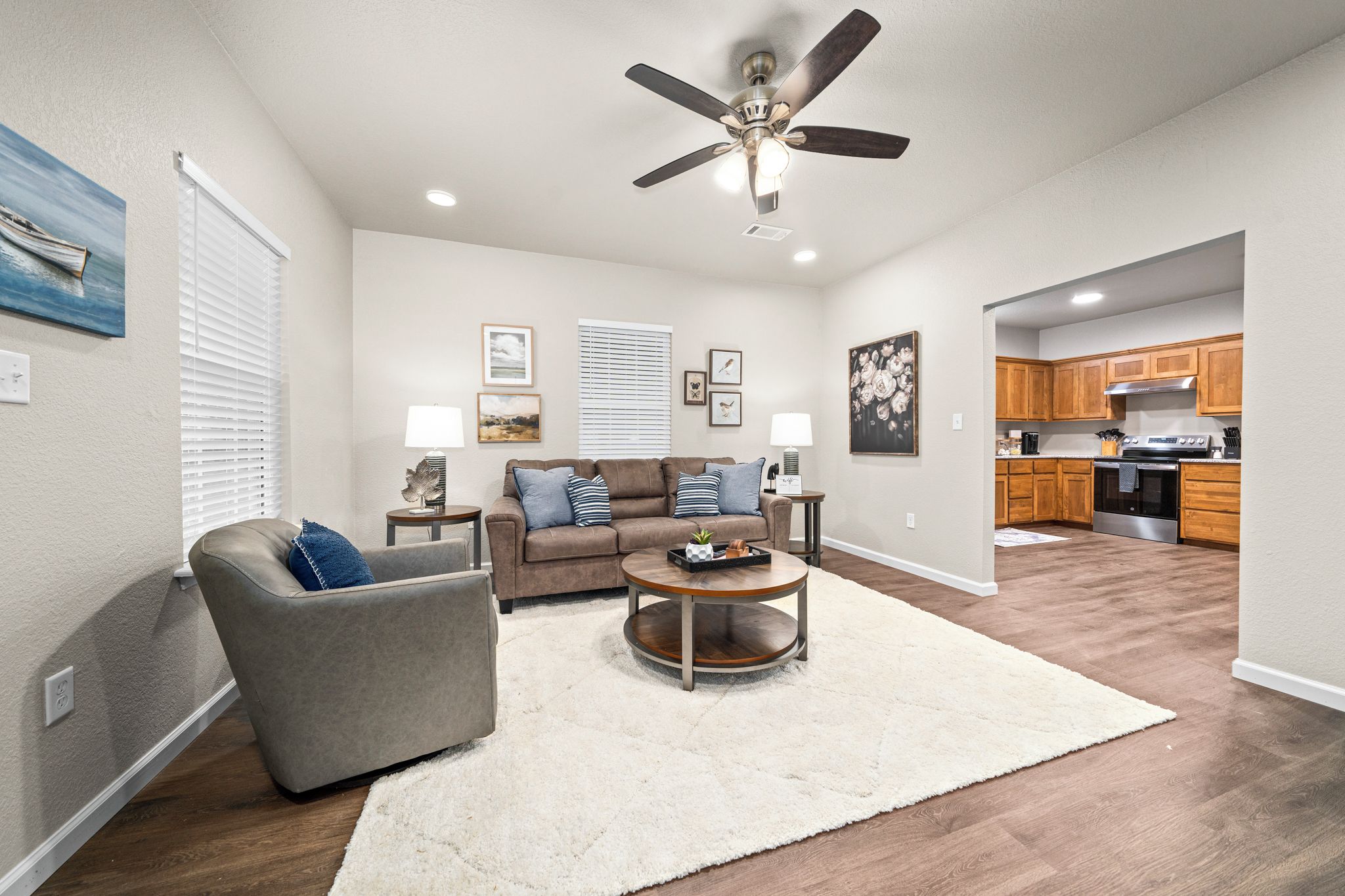 A living room with a sofa, coffee table, and a ceiling fan.