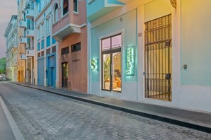 Eine Straße mit einer Reihe bunter Gebäude, darunter ein Hotel mit einer Neonreklame.
