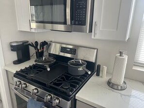 A modern kitchen with stainless steel appliances, including a stove, microwave, and coffee maker. - Private Studio + Parking + Laundry + 15 Min to SD (La Mesa)