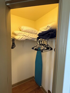 A storage closet with shelves, a hanging rack, and a blue towel. - Updated Pigeon Forge Condo.  3BDR 2BA W/ 2 Pools on the Parkway (Pigeon Forge)