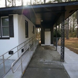 A covered walkway leading to a building with a white exterior and a black door. -  3-bedrooms in Rocky Mount: 5-15 min. of Event & imperial Ctrs & Sports Complex, (Rocky Mount)