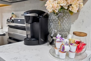 A kitchen counter with a coffee maker, a vase with flowers, and a tray with cups and condiments. -  3-bedrooms in Rocky Mount: 5-15 min. of Event & imperial Ctrs & Sports Complex, (Rocky Mount)