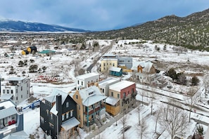 Uma cidade coberta de neve, com diversos edifícios, incluindo uma mistura de construções residenciais e comerciais.