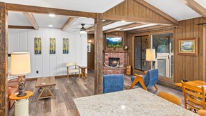 A cozy interior with a fireplace, wooden beams, and a dining area. - Machins House Newly Remodled 4 bdrm backs up against RMNP (Estes Park)