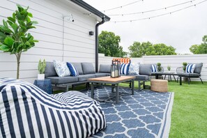 An outdoor seating area with a sofa, chairs, and a table, surrounded by a patterned rug. - Weekend Getaway-Walk to Coffee Shop- 2 Car Garage! (Nashville)