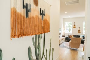 A room with a wall hanging and a cactus mural. - Weekend Getaway-Walk to Coffee Shop- 2 Car Garage! (Nashville)