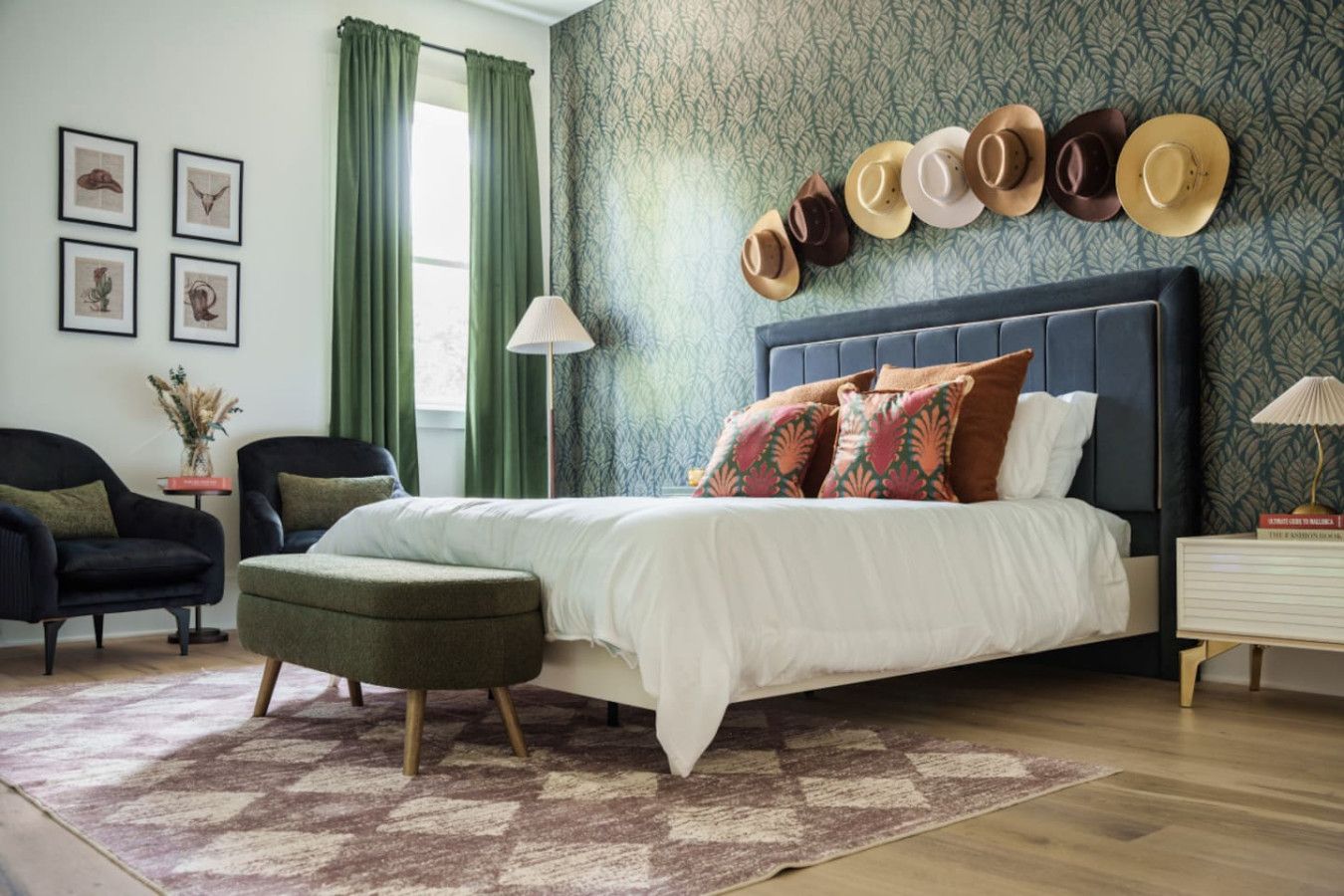 A bedroom with a bed, a chair, a nightstand, and a wall with hats.