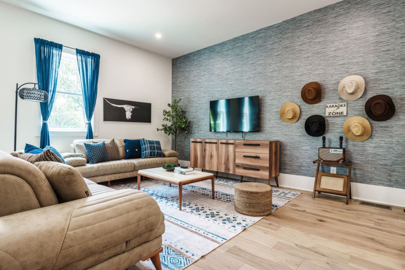 Una sala de estar moderna con un sofá, una mesa de centro y un televisor instalado en una pared con textura.
