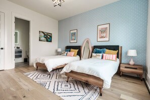 A bedroom with two beds, a patterned rug, and artwork on the walls. - Walk to Coffee and Food - 4 bedroom -2 Car Garage! (Nashville)
