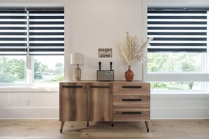 A wooden desk with drawers, a radio, a lamp, and a vase with pampas grass. - 2 Bedroom - Workspace/Fast WiFi - 2 Car Garage! (Nashville)