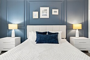 A bed with a white quilt, two white nightstands, two lamps, and three framed pictures on the wall. - Perfect Family Escape, Pool, Themed Rooms (Kissimmee)