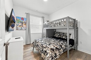 A bedroom with a bunk bed, a desk, a chair, a TV, and a window with curtains. - Lake View Family Escape, 2br, Close to Disney (Kissimmee)