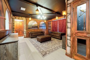 A cozy room with a fireplace, leather sofas, a rug, and a bookshelf. - Dream Family Escape, Pool and Themed Rooms (Clermont)