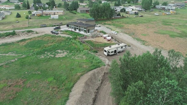 An aerial view of a residential area with a single-story house, a driveway, and a parked RV.