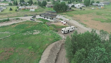 An aerial view of a residential area with a single-story house, a driveway, and a parked RV.